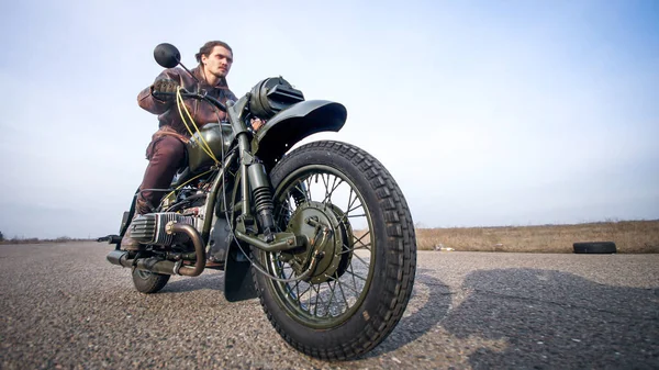 Близкая съемка винтажных мотоциклов колесо на верхом старой пустой дороге — стоковое фото