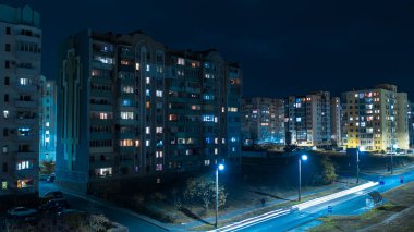  Geceleri aydınlık park manzaralı modern kasabanın üzerinde alçaktan uçuyor. 