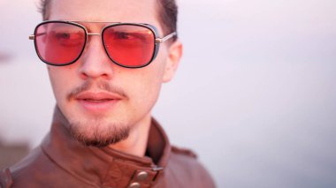 Maço, çekici görünümlü yakışıklı, sakallı, bir portreden rahatsız.