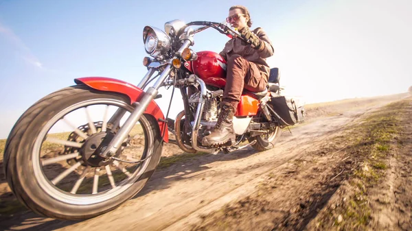 Motorcykel snabb ridning på smuts landsväg genom ett fält i höst solig dag — Stockfoto