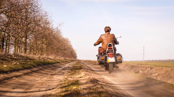 Killen i skinnjacka rider off-road landskap på helikopter i höst solig dag — Stockfoto