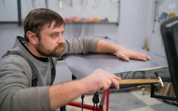 Plan rapproché de l'enlèvement des bosses sans peinture, à l'aide d'un marteau en caoutchouc Images De Stock Libres De Droits