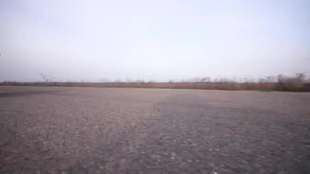 Молодой спорящий на винтажном мотоцикле быстро приближается издалека — стоковое видео