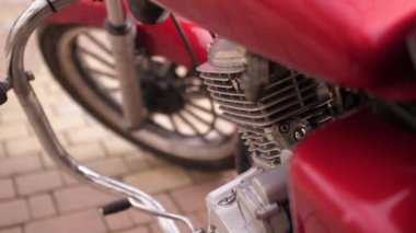 Ağır çekimde yakın çekim. Motosikletin ayrıntıları gün batımında sokakta