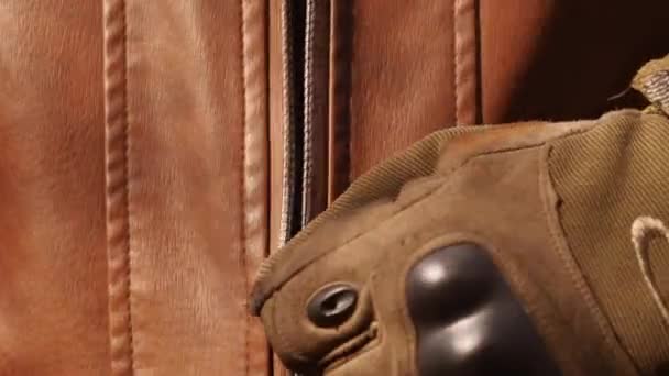 Zblízka natáčení zapínání kožené bundy, mladého pohledného vousatého motorkáře. — Stock video