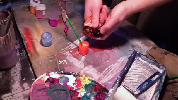 Kunstenaar knijpt oranje kleur uit tube mengen en gieten om te schilderen — Stockvideo