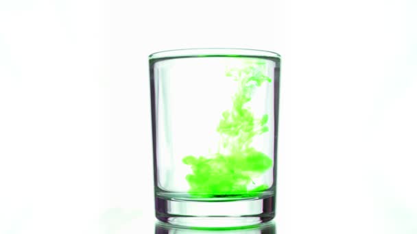 Caída de varias gotas de tinta verde ácido en el vidrio con agua pura — Vídeo de stock