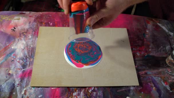 流体芸術のアクリル技術で働くアーティストの手はカップからペイントを注ぐ — ストック動画