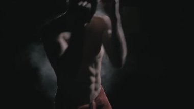 Dövüş sanatlarında çalışan bir sporcu. Karanlıkta gölgesi olan bir sporcu. 