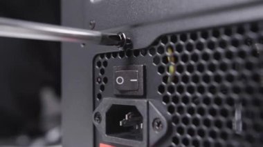 Vidaları yüklemek için tornavida kullanan teknisyen montaj bilgisayarı