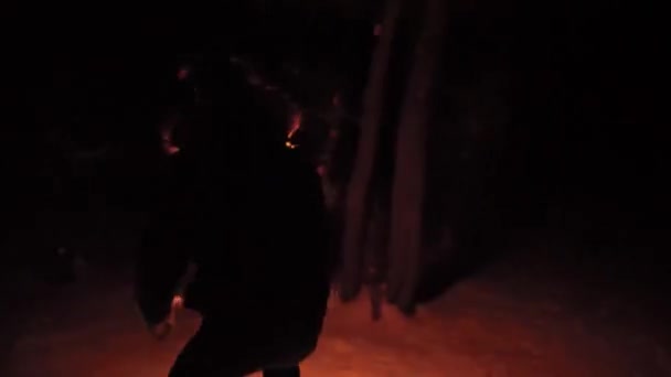 Парень, потерявшийся в ночном лесу зимой бегает с факелом, испуганным — стоковое видео