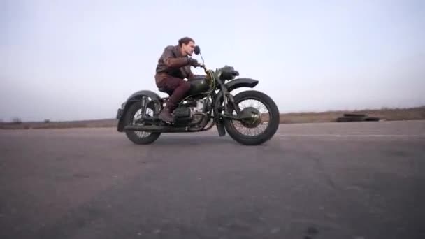 Tiro jovem bicker no vintage motocicleta equitação rápido no o velho estrada — Vídeo de Stock