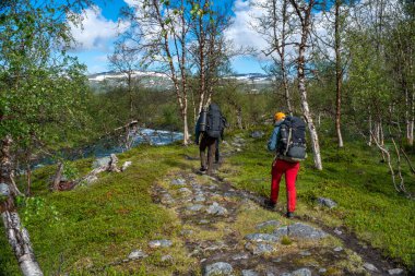 Padjelanta National Park, Beautiful Mountain Scenery and Hiking Trails leading away from Camera with group of hikers trekking and living the wanderlust dream. clipart