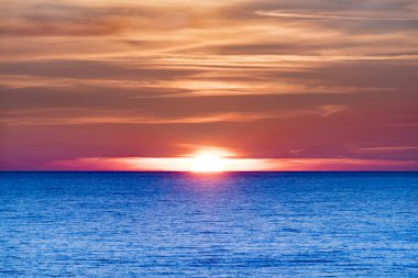 Turuncu Güneş mavi okyanusun üzerinde batıyor. Sahilde batan güzel güneş, Tylosand Halmstad, İsveçlilerin en popüler plajlarından biri..