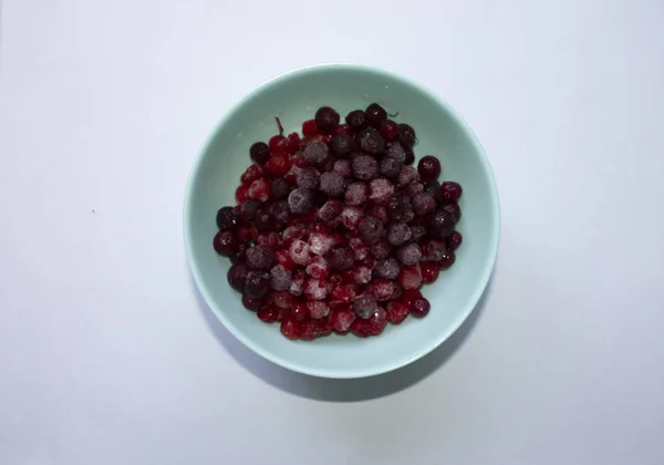 Unfokussierte blaue Tasse mit gefrorenen Preiselbeeren — Stockfoto