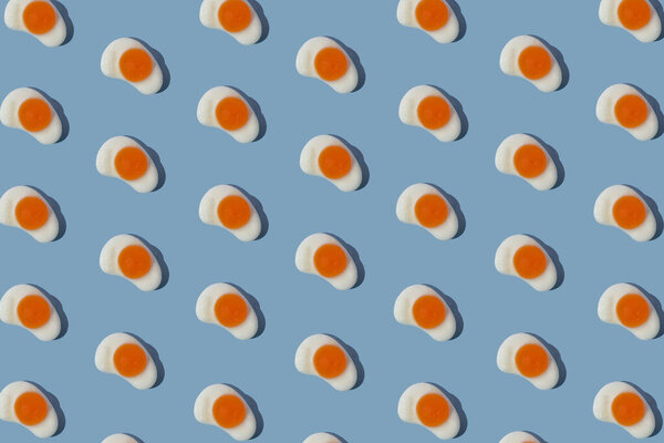 Minimal creative pattern with candy eggs on pastel blue background. Creative flat lay concept.