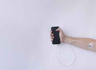Cep telefonu elinde, infüzyonla bağlantılı. Modern yaşam tarzı. Beyaz arka plan. Asgari yaratıcı yaşam tarzı konsepti.