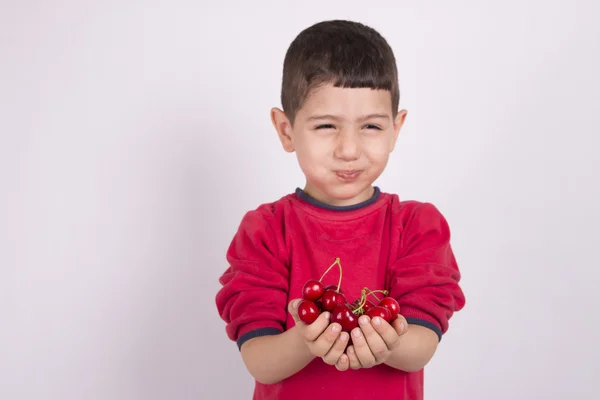Hrst cherry a chlapec jíst — Stock fotografie