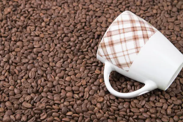 raw coffee beans and coffee cup