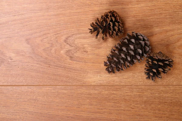Соснові шишки на дерев'яній підлозі — стокове фото
