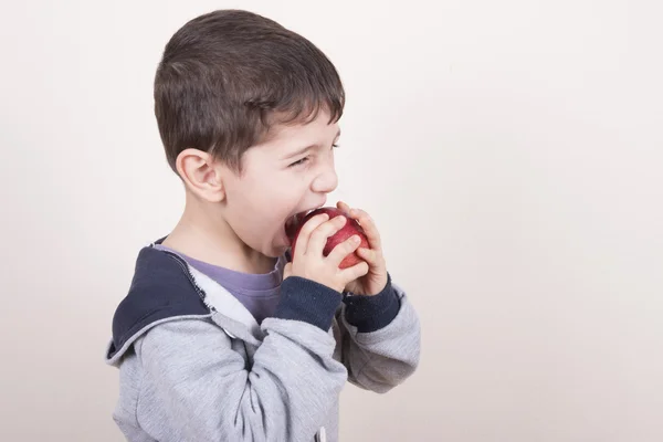 Menino mordida maçã vermelha — Fotografia de Stock