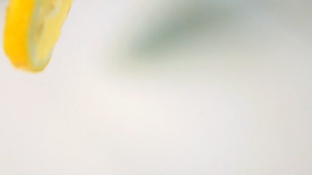 Des morceaux de citron tombent dans le lait. Mouvement lent 