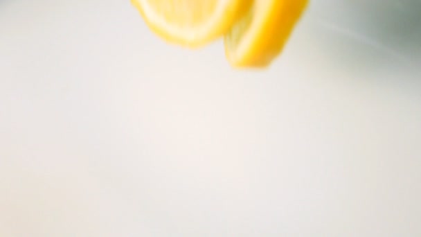 Des morceaux de citron tombent dans le lait. Mouvement lent 