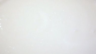 Beyaz yüzey üzerine süt yağmur