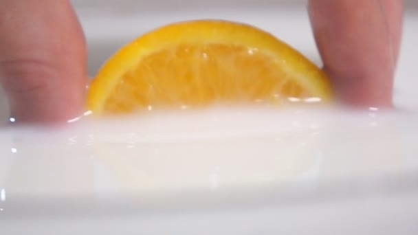 Pulling orange from the milk — Stock Video