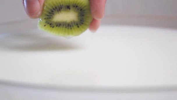 Putting kiwi into the milk — Stock Video