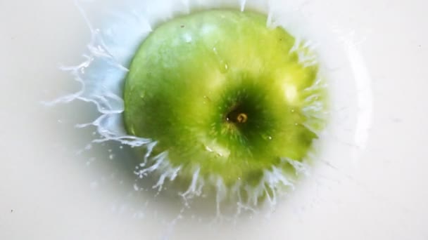 Зелене яблуко потрапляє в молоко — стокове відео
