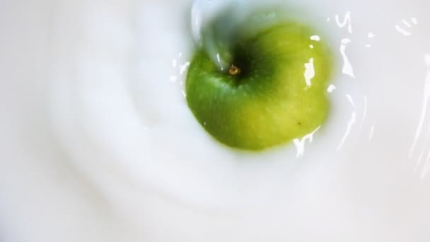 Pomme verte tournante fait un tourbillon dans le lait — Video