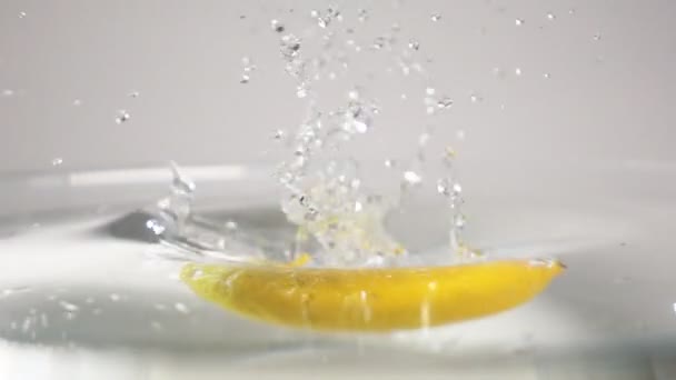 Лимон падает в воду — стоковое видео