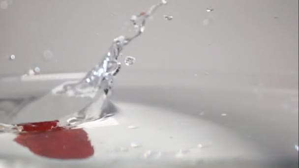 Three strawberries drop into water — Stock Video