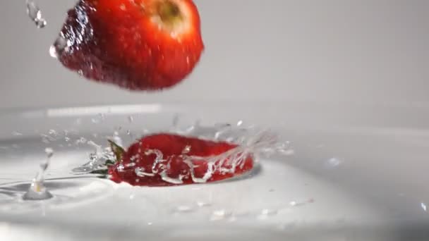 Tres fresas sumergidas en agua — Vídeo de stock