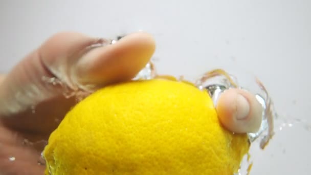 Опуская лимон в воду — стоковое видео