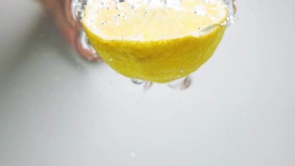 Половина лимона попала в воду — стоковое видео