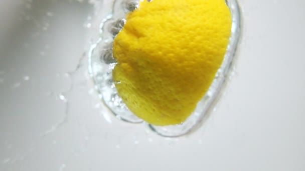 Un demi citron tombe dans l'eau 