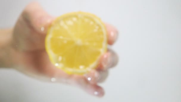Druppels water vallen van citroen helft op oppervlak — Stockvideo