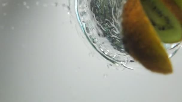 Kousky kiwi zaposlouchat do vody — Stock video