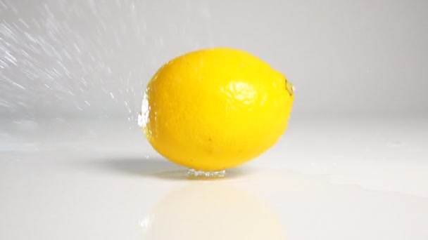 Lemon legördülő fehér felületre — Stock videók