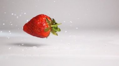 Çilek beyaz ıslak yüzeye düşer