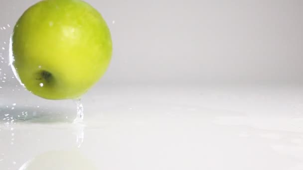 Pomme verte Tomber sur la surface blanche 