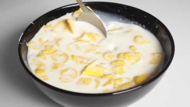 Cornflakes mit einem Löffel in Milch mischen — Stockvideo