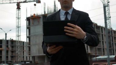 İşadamı yeni inşaat yakınındaki dijital panelini kullanma