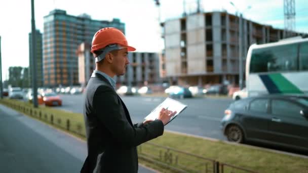 Trabajador de construcción. Arquitecto mira el plano de papel de la construcción — Vídeo de stock