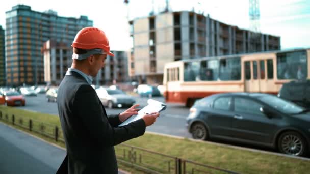 Εργάτης οικοδομών. Αρχιτέκτονας ματιά στο χαρτί το σχέδιο του κτιρίου — Αρχείο Βίντεο