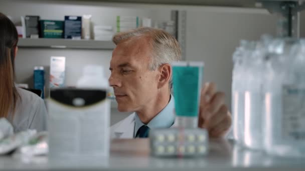 Ein erwachsener Apotheker überprüft das Produkt im Inneren einer modernen Apotheke — Stockvideo