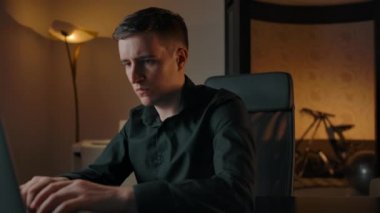 Genç bir adam dizüstü bilgisayarda çalışıyor, klavyede yazıyor.