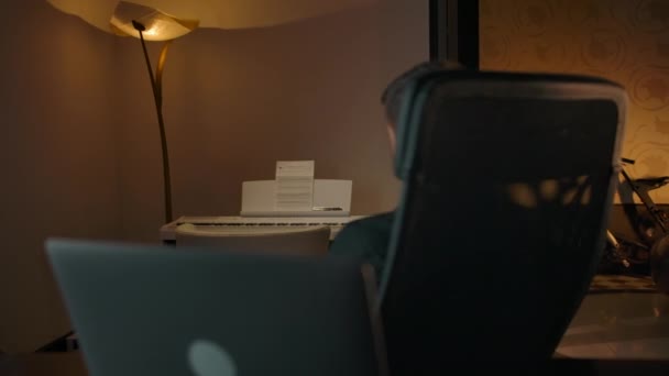 A férfi megpördül a széken, és gépelni kezd a laptop billentyűzetén. — Stock videók